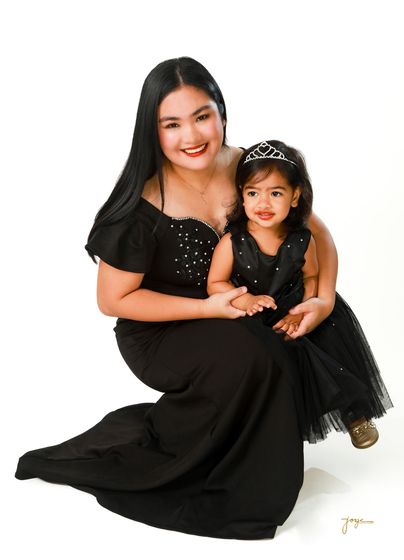 A mother and daughter in matching black gowns