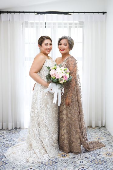 Two women in formal gowns holding bouquets