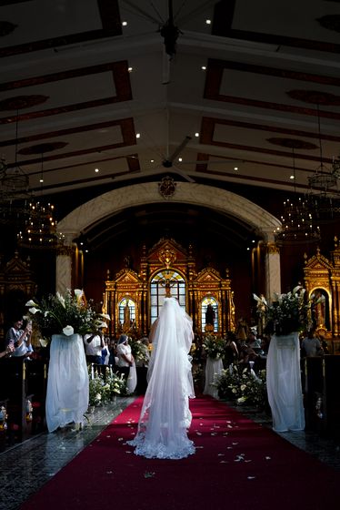 The bride's entrance down a candlelit church aisle